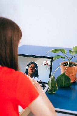 Lady in red top on a video call on her laptop