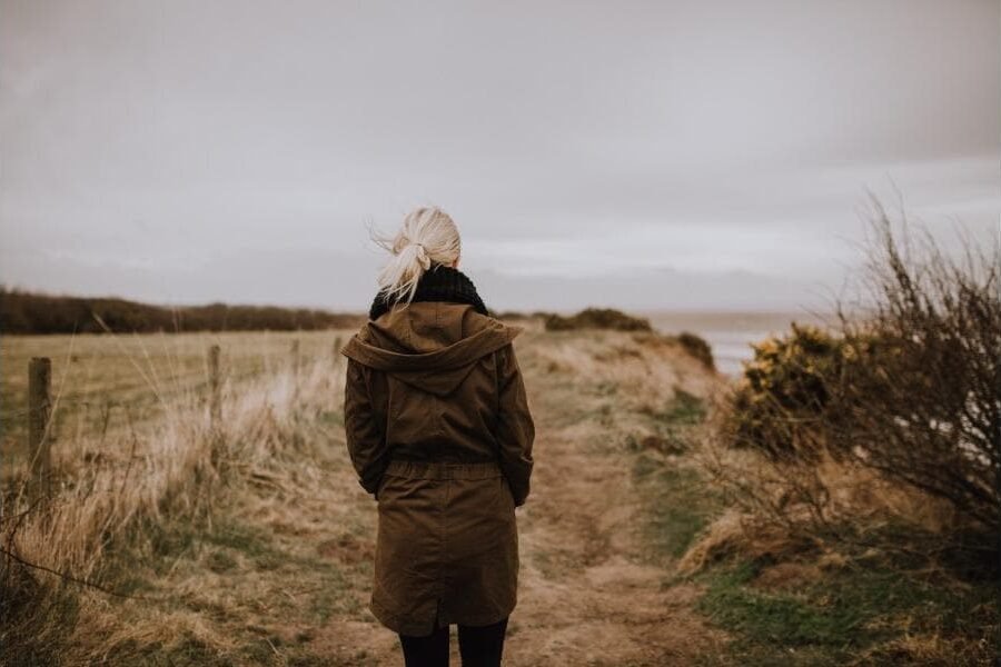 Woman walking alone along a coastal path